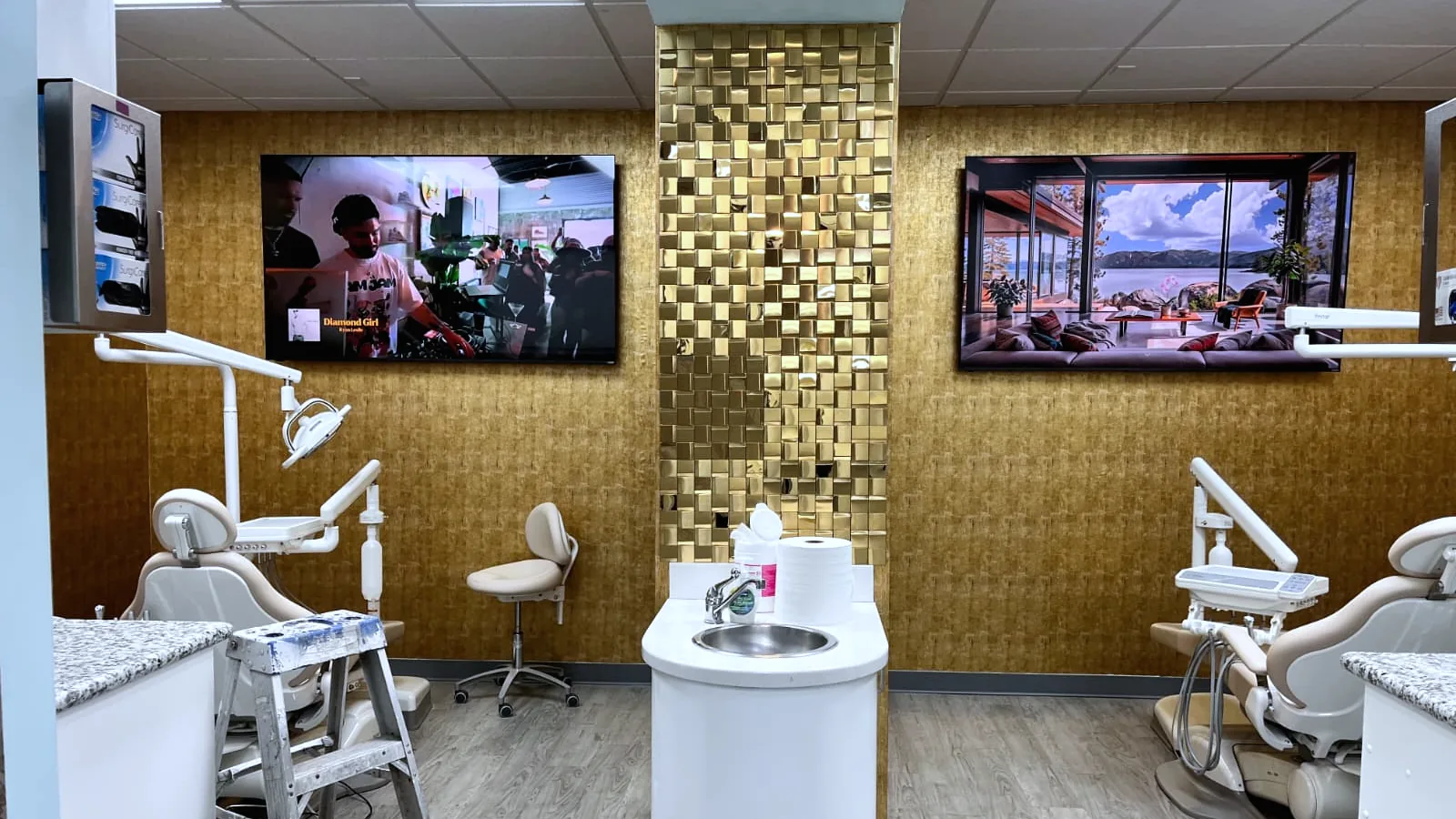Treatment rooms at Diamond Smiles Dental, with a gold mosaic column between wall-mounted screens