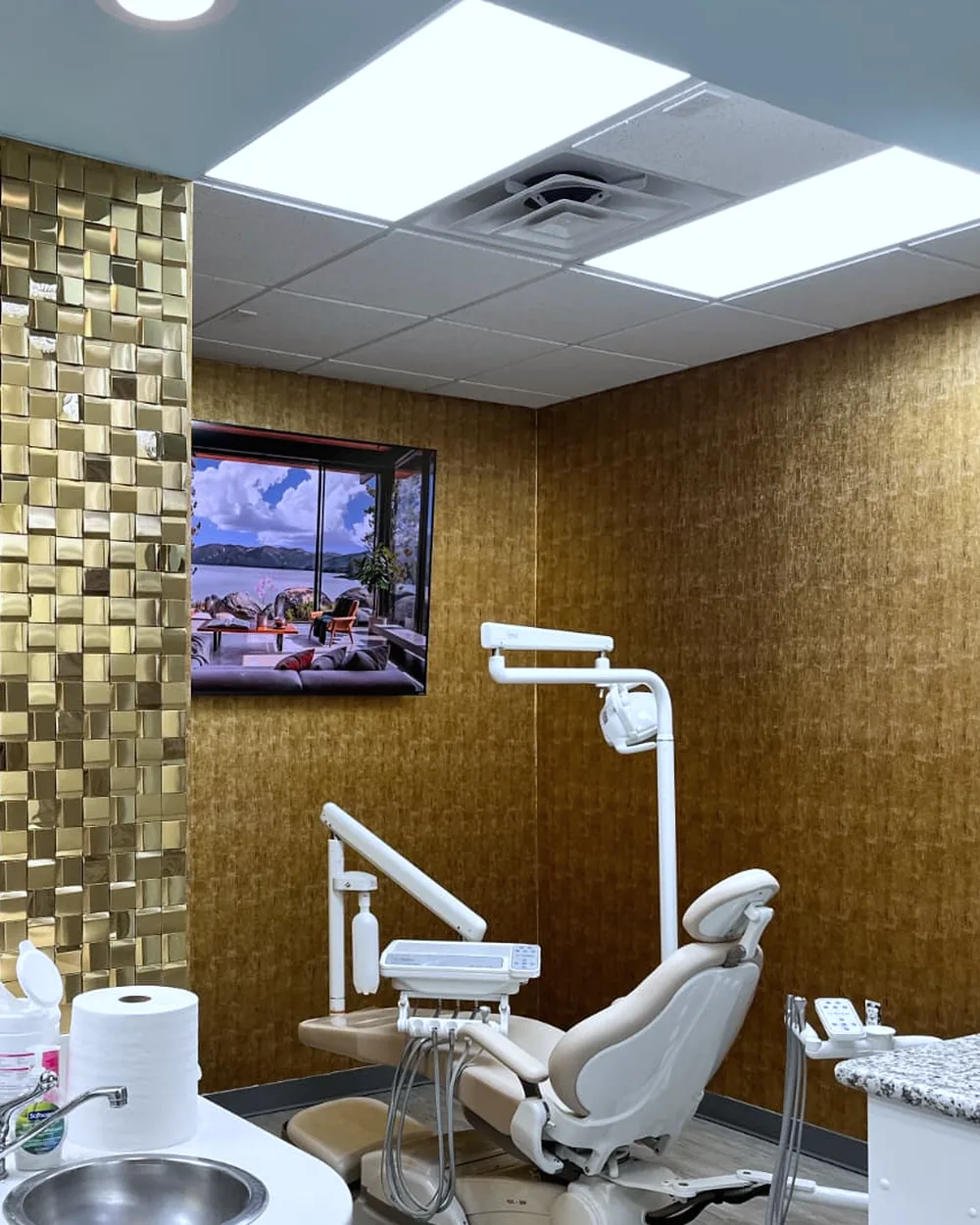 A treatment room at Diamond Smiles Dental, with a gold mosaic wall beside the dental chair